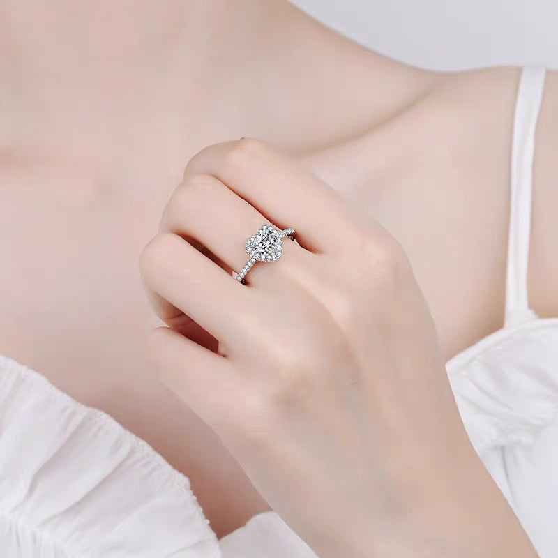 a woman's hand holding a diamond ring