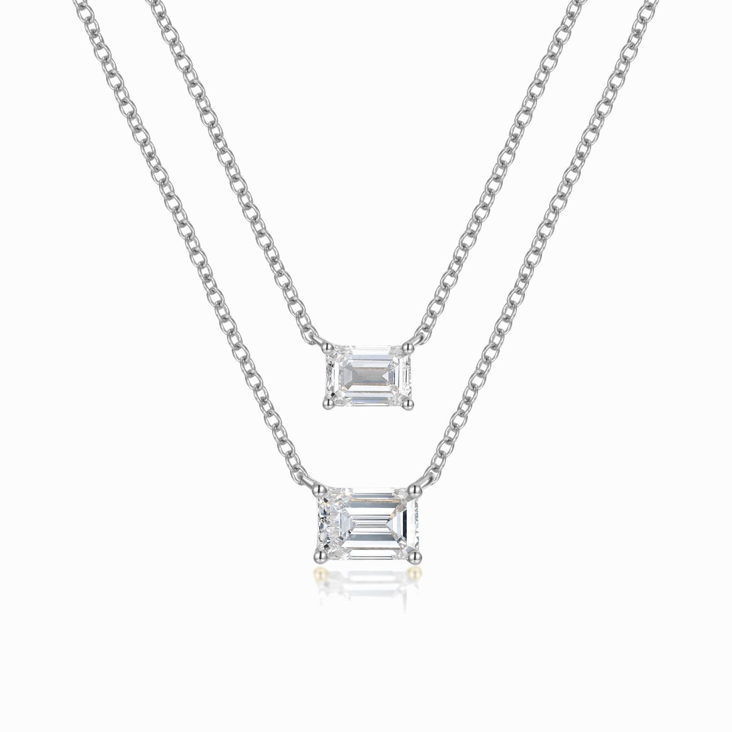 a pair of necklaces with a baguette pendant