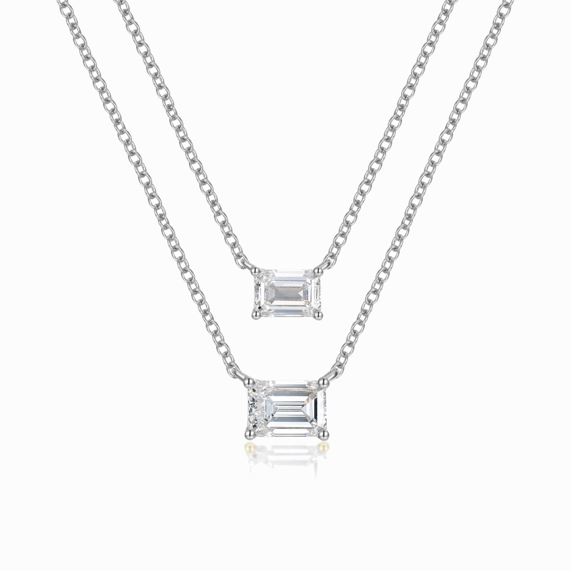 a pair of necklaces with a baguette pendant