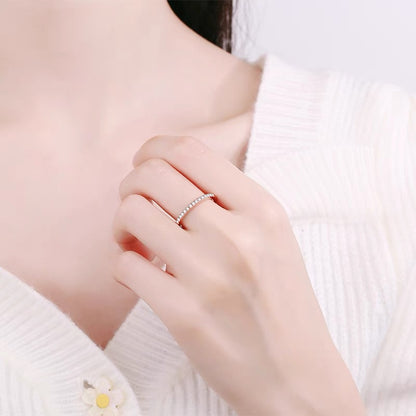 a woman wearing a white sweater and a diamond ring